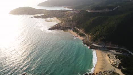 Luftaufnahmen,-Die-über-Dem-Strand-Kreisen-Und-Sonnenstrahlen-Zeigen,-Die-Sich-Im-Meer-Spiegeln