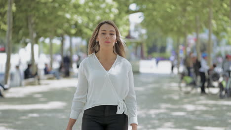 Attractive-girl-talking-at-camera-and-walking-outdoor