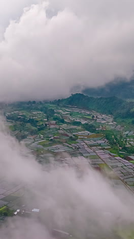 a vibrant patchwork of farmland unfolds beneath drifting clouds in lombok, indonesia - timelapse