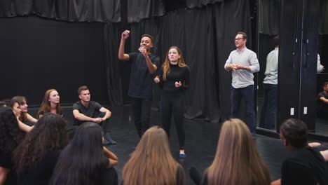 teacher with drama students at performing arts school in studio improvisation class