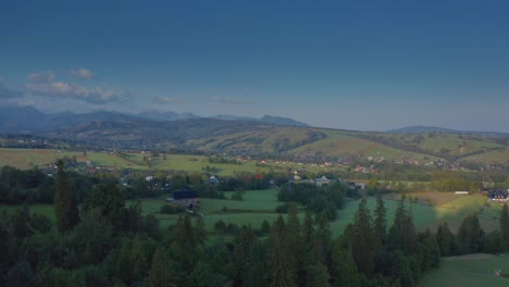 Scenic-Aerial-View-Of-Villages-Below-Mountain-Pastures-In-Dzianisz,-Podhale-Region-In-Southern-Poland