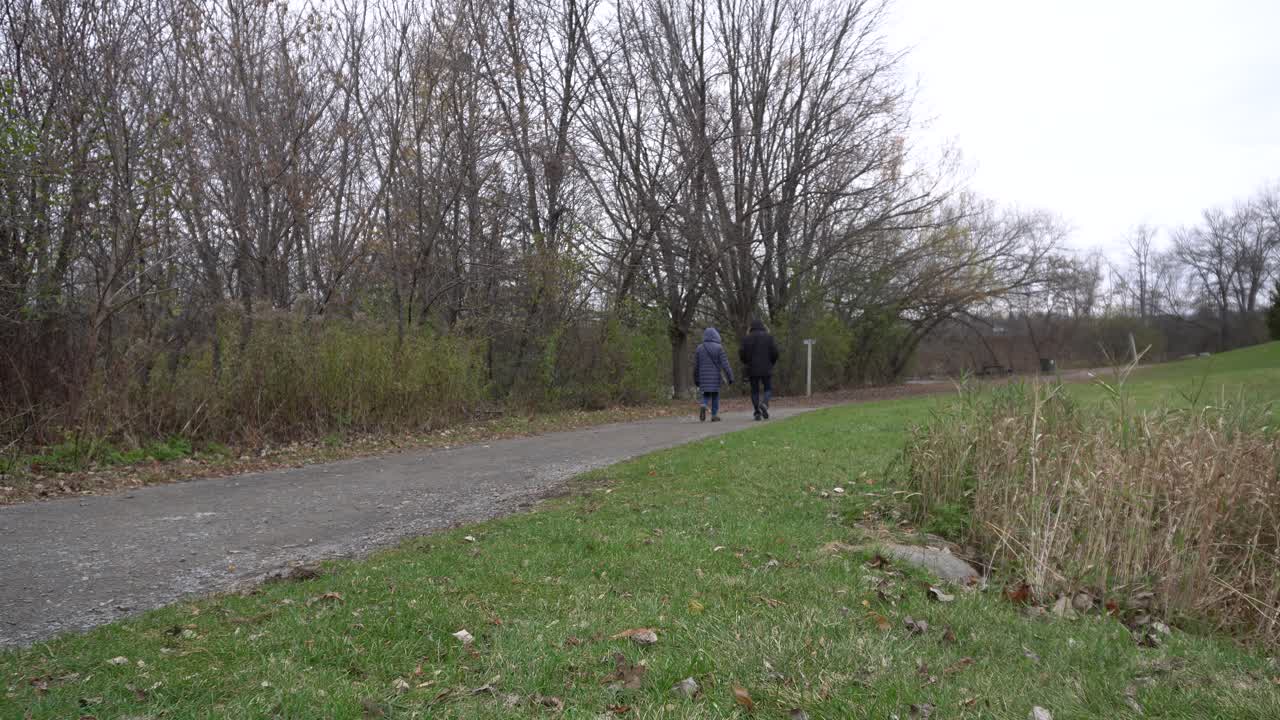 Couple Walking on a Path in a Park During Autumn