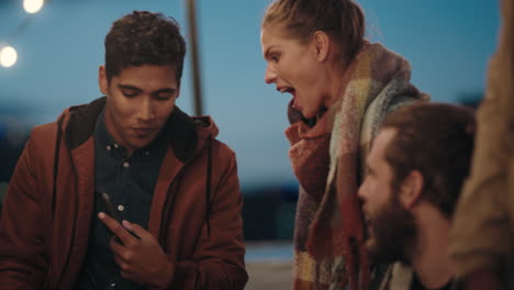 diverse rooftop party friends hanging out chatting having fun socializing together enjoying happy reunion gathering at night