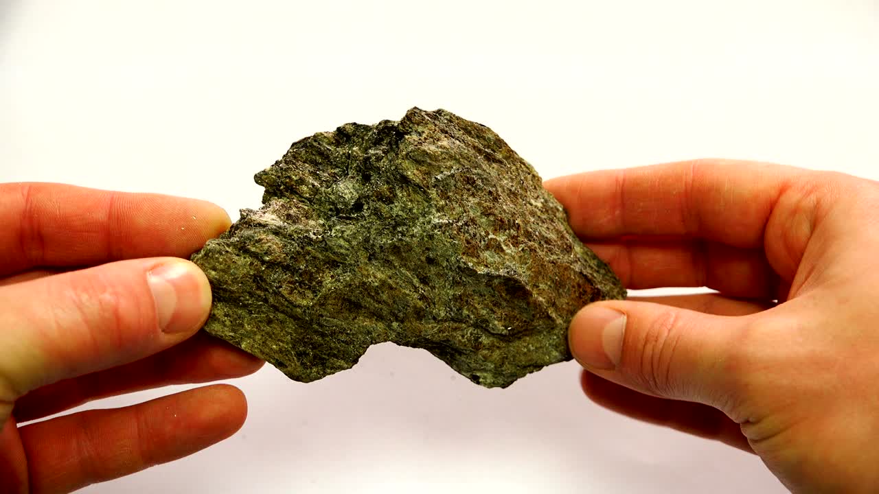 a mineral of dirty green color with a prominent garnet stone