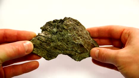a mineral of dirty green color with a prominent garnet stone