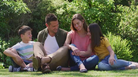 Caucasian-family-smiling-while-sitting-together-in-the-garden