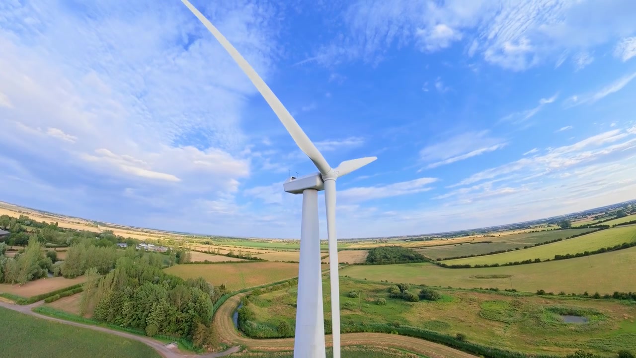 aerial drone footage, Sunset view over a field of renewable energy sources featuring wind turbines and natural scenery. Lincolnshire solar panel arrays wind turbines countryside, England