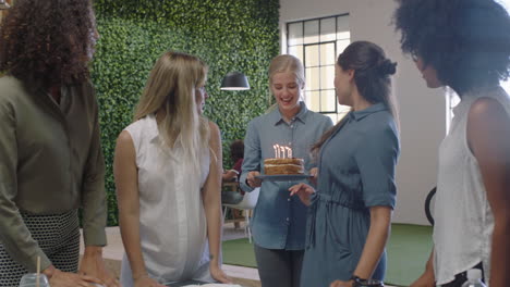 feliz gente de negocios celebrando fiesta de cumpleaños jefe mujer soplando velas disfrutando de la fiesta en la oficina lugar de trabajo