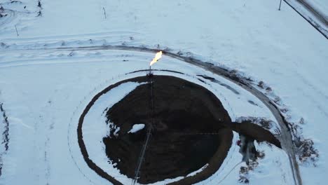 aerial view gas burning from flare structure in oilfield winter