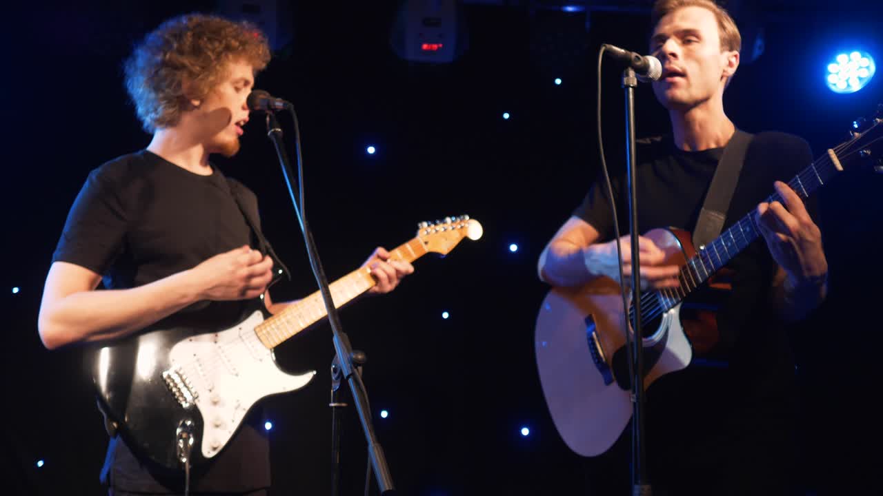 콘서트 록 밴드, 두 개의 전기 기타와 함께 무대에서 공연하는 가수, 뮤직비디오 크, 헤비 메탈 또는 록 그룹, 느린 동작 악기 연주 두 사람의 밴드