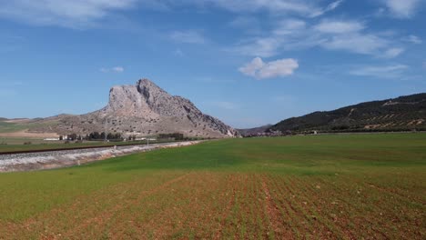 Spectacular-aerial-flight-over-the-enclave-of-Peña-de-los-Enamorados,-a-rock-formation-in-the-shape-of-a-human-face-in-the-municipality-of-Antequera-in-Andalusia,-Spain