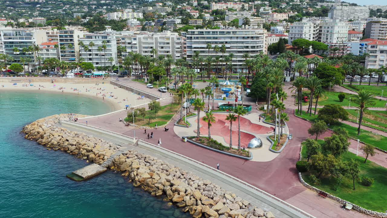 Vista aerea con drone della promenade, del parco sulla spiaggia con palme e degli edifici residenziali vicini, Cannes, Francia