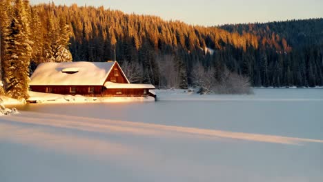cabaña de invierno en el lago congelado al amanecer