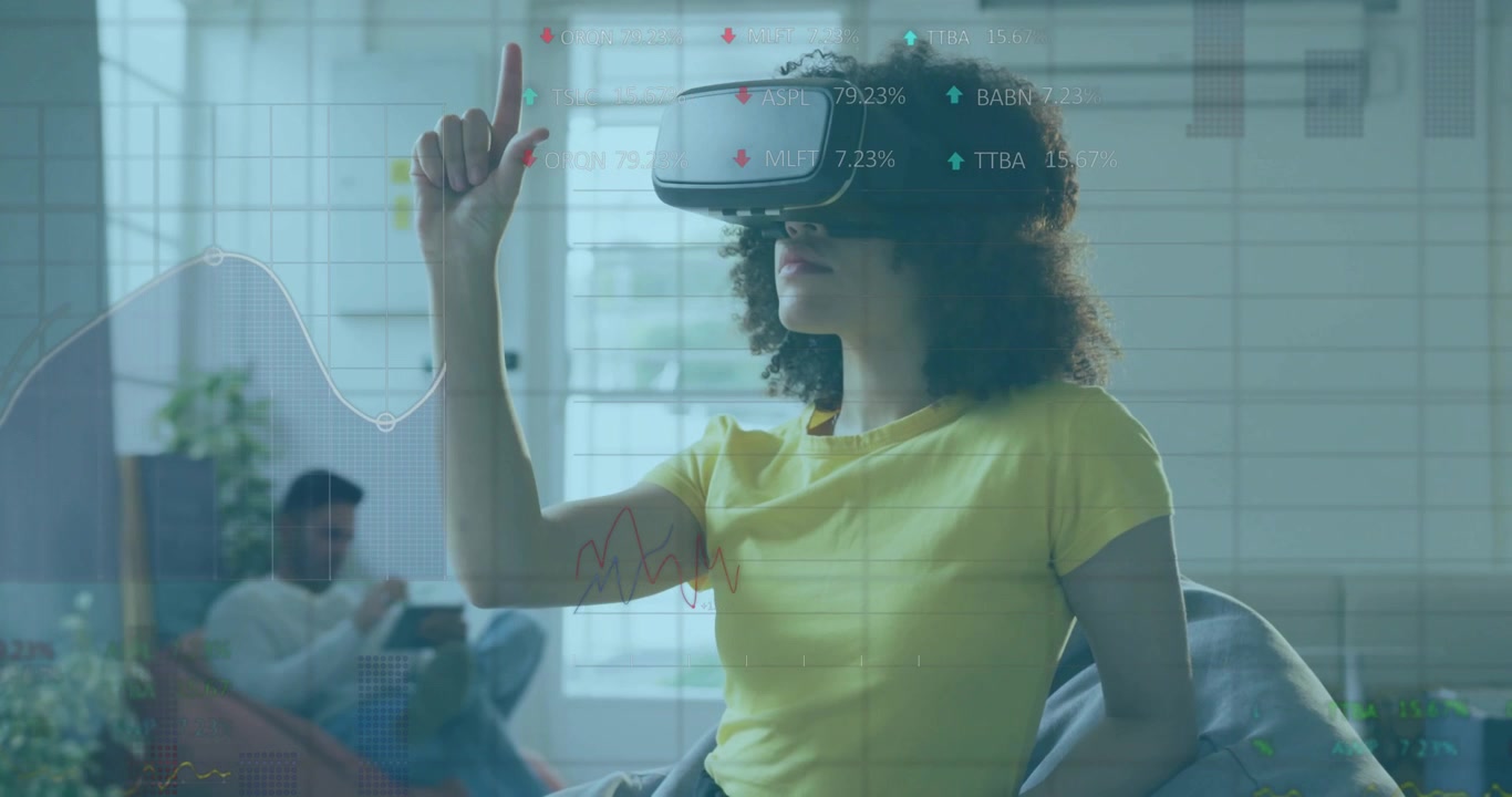 Žena s VR headsetem zvedá prst nad průsvitnými finančními grafy, muž s tabletem.