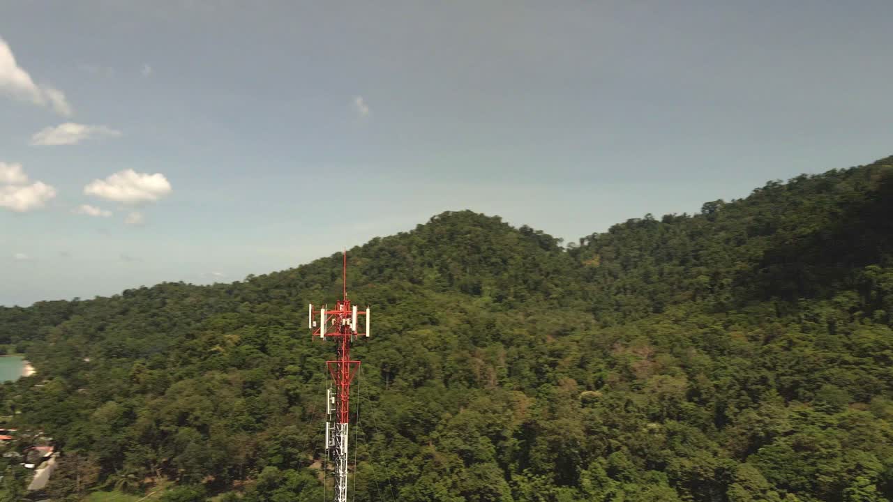 toma aérea de la torre de telecomunicaciones en una isla tropical con selva y océano