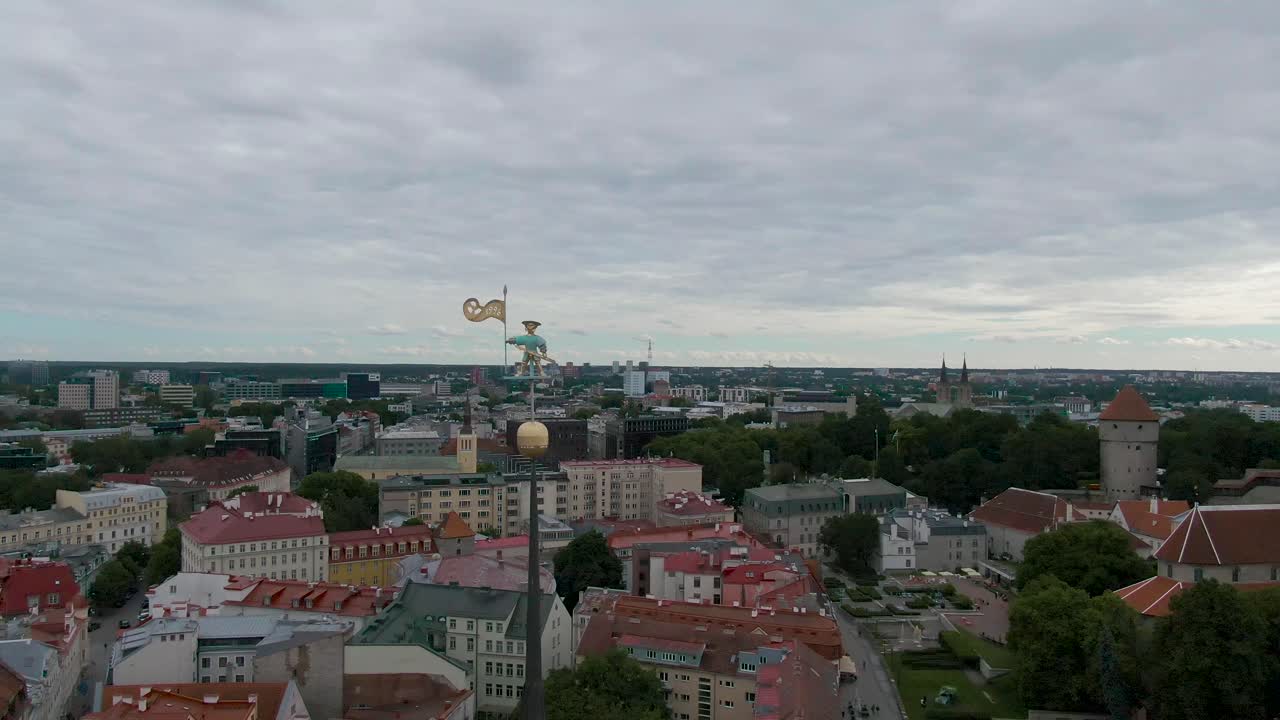 una toma de dron de old thomas en la parte superior de un edificio tallinn estonia sosteniendo una bandera dorada