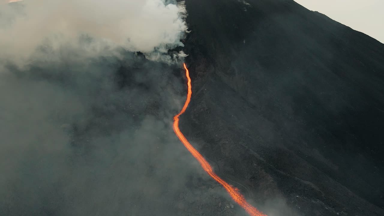 drone aéreo volando a través de las nubes, hermoso paisaje de lava que fluye de la erupción del volcán pacaya en guatemala