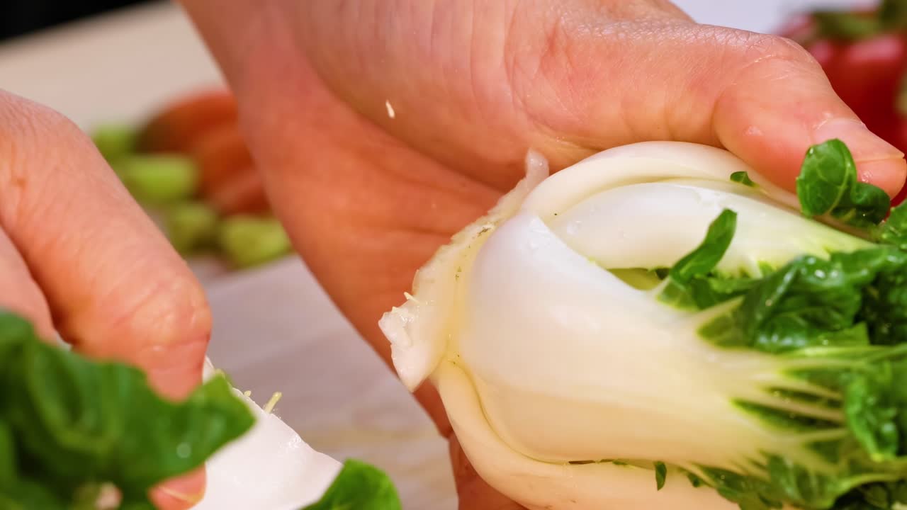 Hands cleaning and trimming baby bok choy