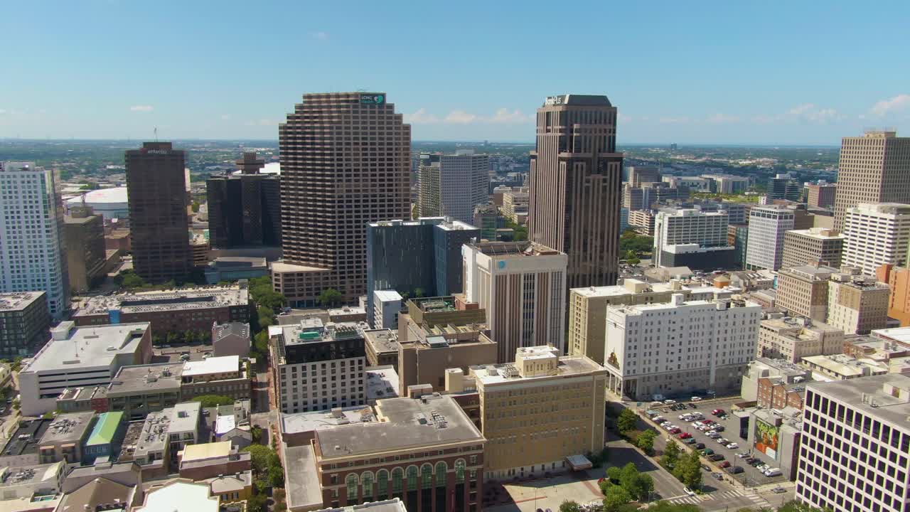 A panning aerial shot of the Central Business District in New Orleans on a Sunny day. The clip features skyscrapers, an urban layout, and a blue sky