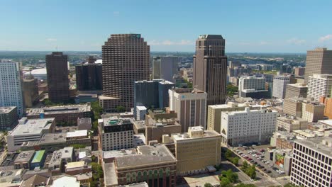 a panning aerial shot of the central business district in new orleans on a sunny day. the clip features skyscrapers, an urban layout, and a blue sky