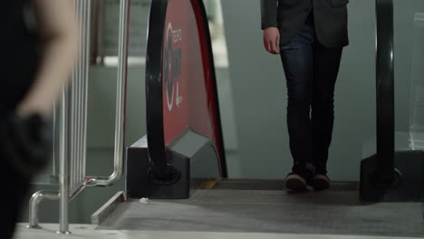 person walking up escalator