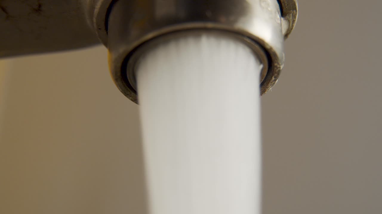 물을 낭비하는 떨어지는 수도꼭지의 매크로 샷