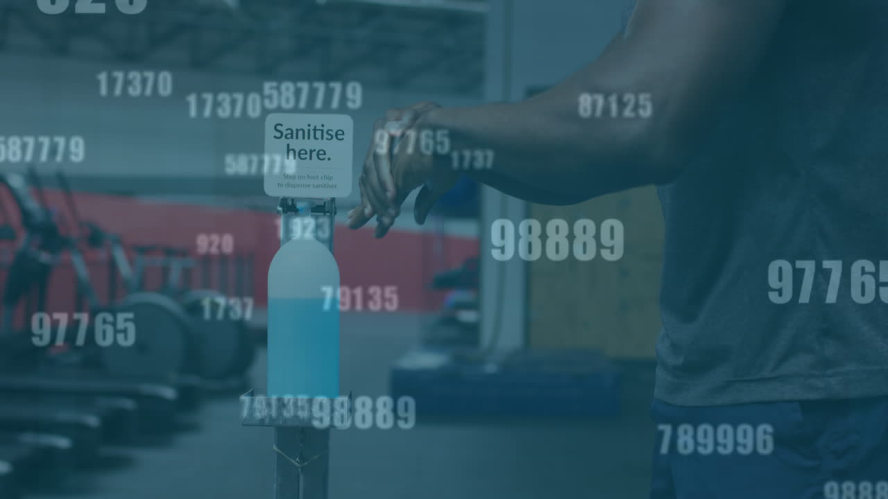 Multiple changing numbers against mid section of man using hands sanitizer at the gym