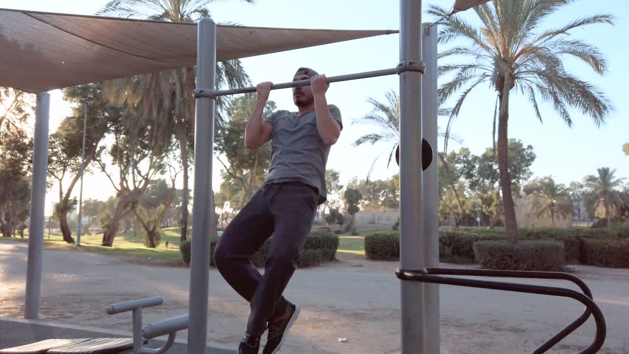 young man doing pull ups on horizontal bar