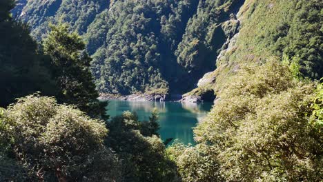 panning shot of beautiful lake marian lighting during sunny day between vegetated mountains