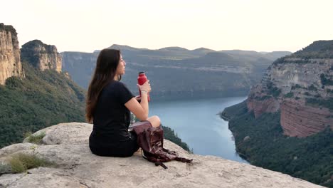 Señorita-Bebiendo-Agua-Mientras-Se-Recrea-En-Un-Acantilado-Rocoso-Durante-Una-Excursión