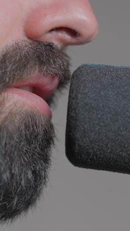 close-up of a man speaking into a microphone