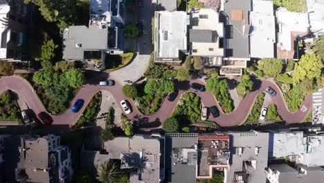 Wide-aerial-bird's-eye-shot-looking-down-at-cars-driving-on-crooked-Lombard-Street-on-Russian-Hill-in-San-Francisco,-California