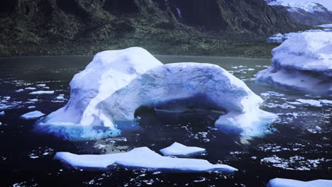 large ice arch formation in a serene glacial bay during daylight