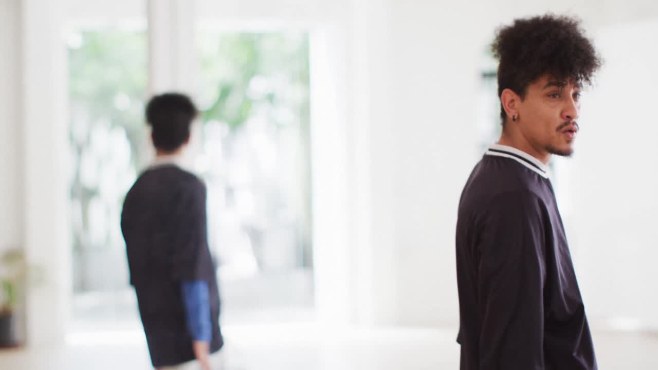 댄스 스튜디오에서 거울 앞에서 혼자 춤을 추는 두 인종의 남성 댄서, 슬로우 모션