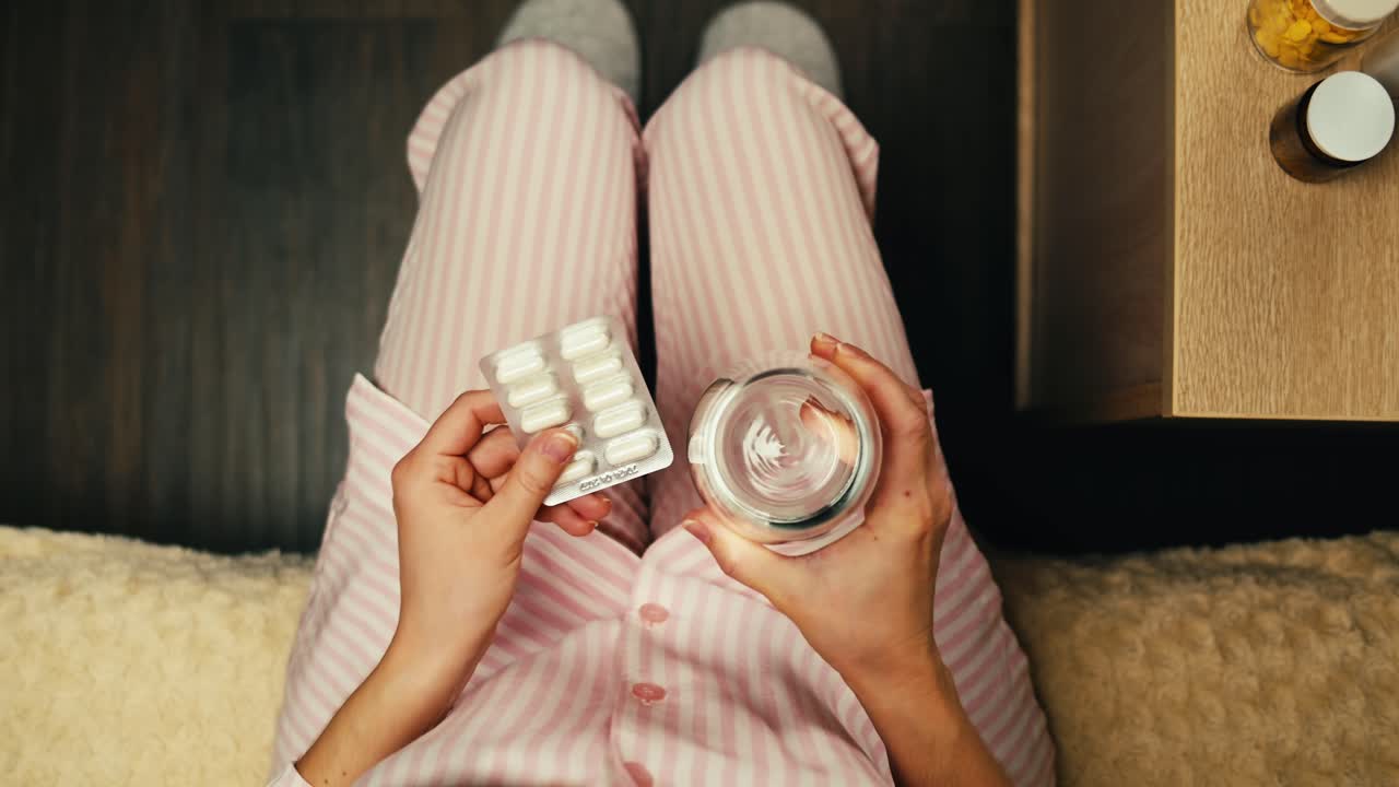 mujer tomando medicamentos en pijama