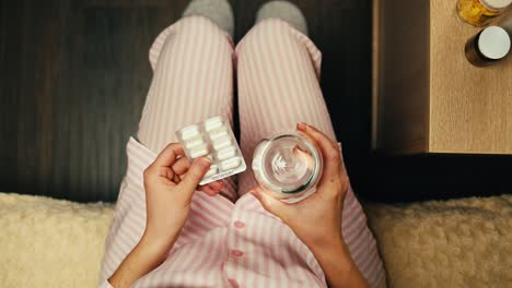 mujer tomando medicamentos en pijama