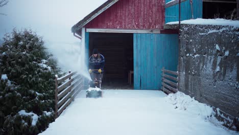 a man is employing a snow blower to remove the accumulated snow in indre fosen, trondelag county, norway - static shot