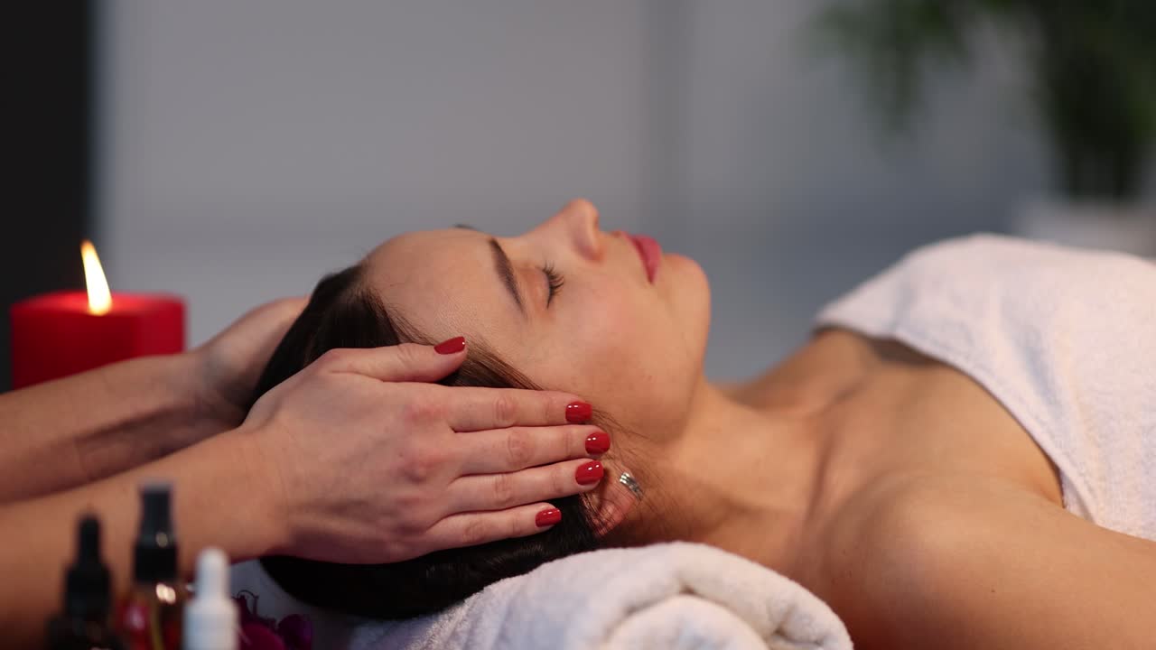 una mujer recibiendo un masaje de cabeza en un spa.