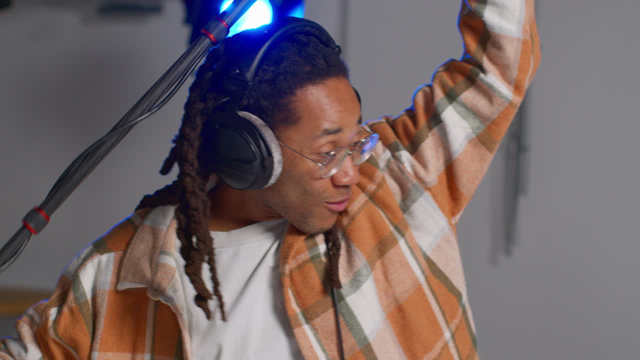 primer plano de un grabador de sonido de película masculino con auriculares sosteniendo un micrófono disparando una película o video en el estudio 3