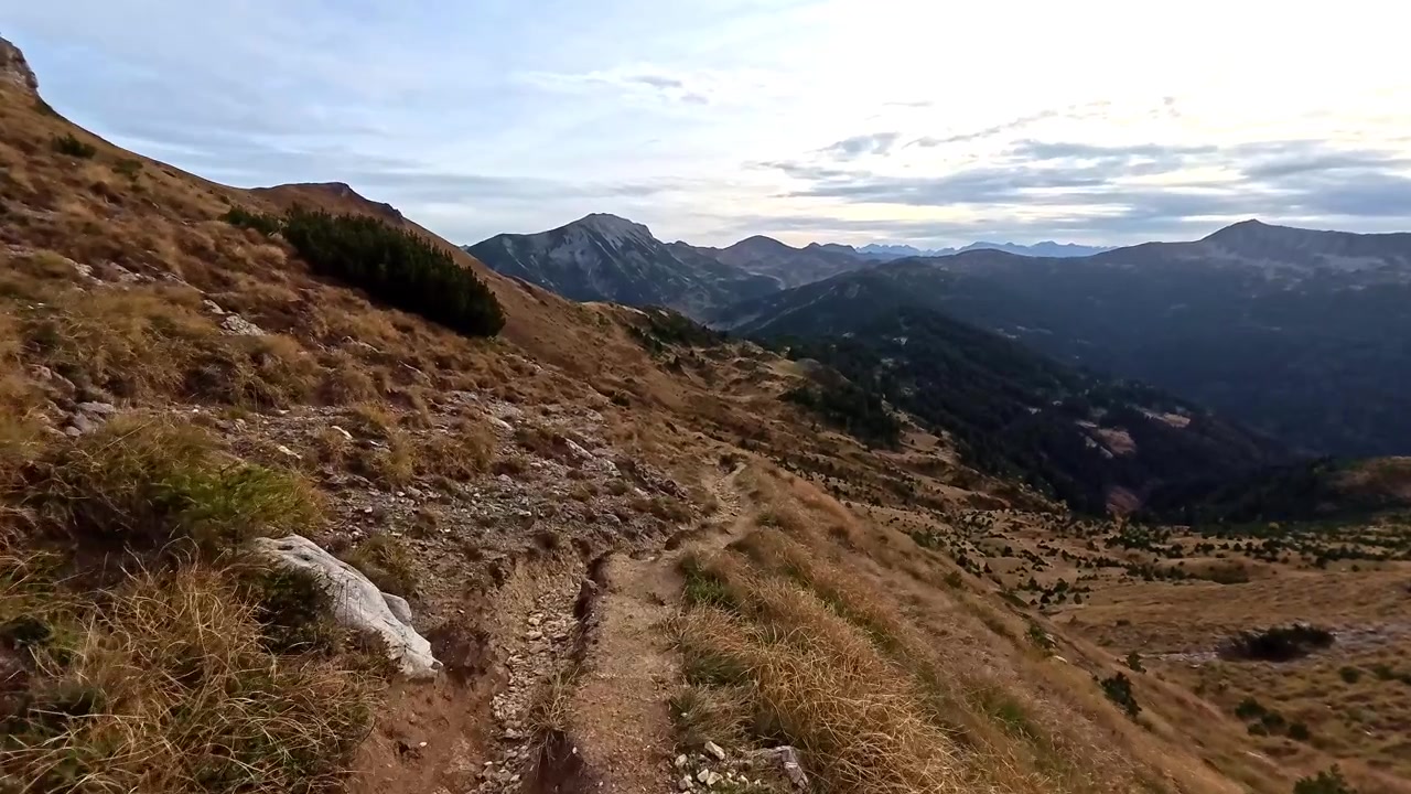 Camminare lungo stretti sentieri di montagna circondati da cime imponenti. Vivi la serena atmosfera serale sul sentiero.