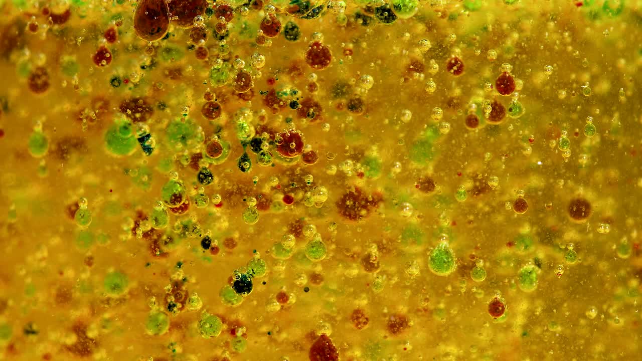 reacción química vibrante con gotas de colores en un vaso, mostrando la densidad y la separación durante 16 segundos