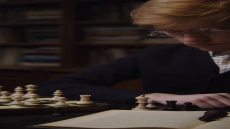 man concentrated on chess game in a library