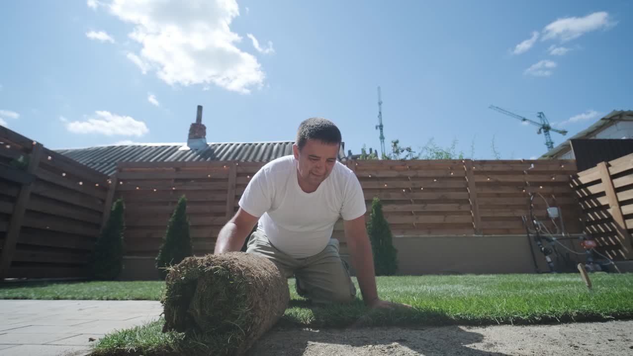 잔디 설치 및 조경 프로젝트를 위해 뒷마당 정원에 소드 풀을 는 사람, 주거 마당의 신선하고 푸른 잔디를 위해 집 개선 및 야외 유지에 초점을 맞추고 있습니다.