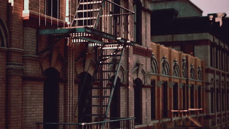 a close-up view of a fire escape on a brick building in a city.