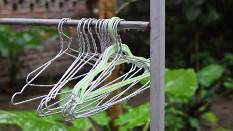 hand arranging white clothes hangers on a rack