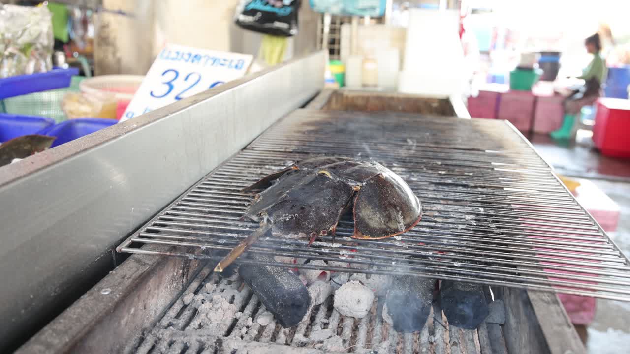 야외 시장 에서 그릴 에 생선 을 조리 하고 있다