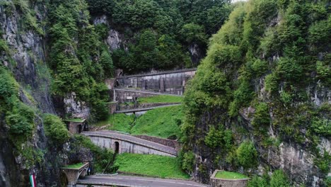 curving alpine road cuts through steep cliffs of san boldo pass under cloudy sky