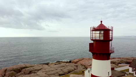 antena acercándose a la torre superior de la linterna del faro de ryvingen con fondo del mar del norte - marca de navegación marítima de la costa de noruega fuera de mandal