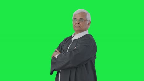 retrato de un abogado senior indio de pie con las manos cruzadas pantalla verde