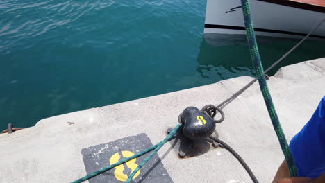 marinero prepara un nudo marinero para colocarlo en el bolardo de amarre